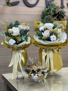 two bouquets of flowers sitting on top of a table