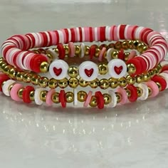 three bracelets with red, white and gold beaded hearts on each strander