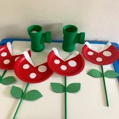 some paper plates and cups are on a tray with green plants in the middle of them