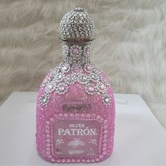 a pink bottle that is sitting on top of a white tablecloth and some fur behind it