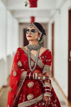 a woman in a red and gold bridal outfit is standing on the hallway way