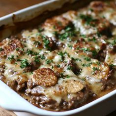 a casserole dish with meat and cheese in it on top of a wooden table