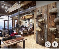 the inside of a shop with wooden walls and bags hanging from it's hooks