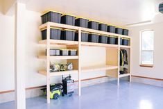 an empty room with several shelves and bins on the wall next to each other