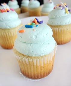 cupcakes with white frosting and sprinkles on top