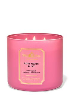 a pink candle that is sitting in front of a white background with the words rose water and ivy on it