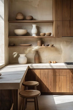 a kitchen with wooden cabinets and shelves filled with vases on top of the counter