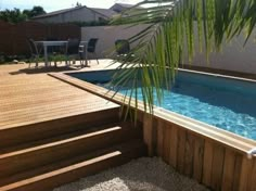 an above ground pool with steps leading up to it and a palm tree in the middle