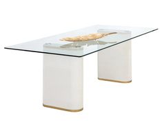 a glass table with a gold leaf on the top and white base, against a white background