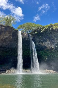 a large waterfall that is next to a body of water