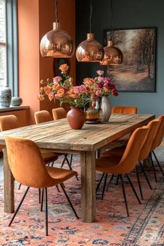 a dining room table with orange chairs and vases on top of it in front of a large window