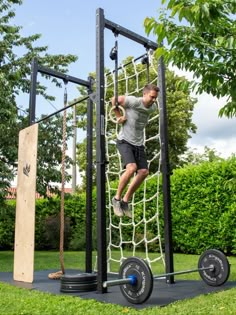 a man is hanging on to a rope in the park while using a pull up bar