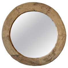 a round wooden mirror hanging on the wall