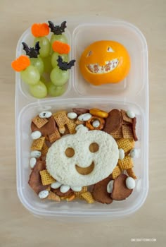 a plastic container filled with food and fruit on top of a wooden table next to an orange