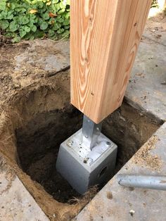 a hole in the ground that has been dug into by a metal pipe with a wooden post sticking out of it