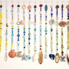 there are many different beads and charms on the wall next to each other, including seashells