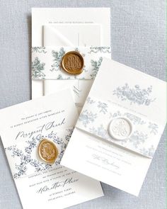 three wedding cards with wax stamp on them and envelopes in the same color scheme