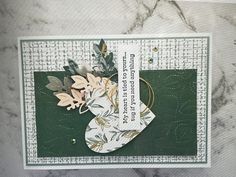 a close up of a card on a table with flowers and leaves attached to it