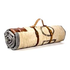 a rolled up blanket sitting on top of a white floor next to a brown bag