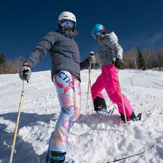 two people on skis standing in the snow