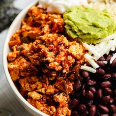 a bowl filled with beans, rice and guacamole