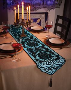 the table runner is decorated with candles and plates