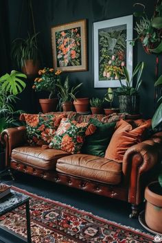 a living room filled with lots of potted plants next to a brown leather couch