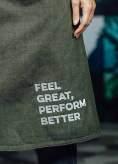 a person wearing an apron with words on it that read feel great, perform better