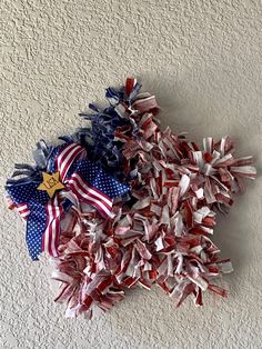 two red, white and blue bows are on the floor next to each other in front of a wall