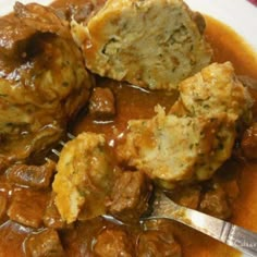 meatballs and gravy on a plate with a fork