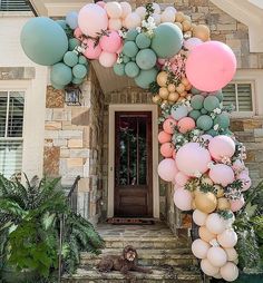 a bunch of balloons that are on the front of a house with stairs leading up to it