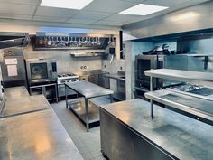 an industrial style kitchen with stainless steel appliances and counter tops on both sides, including stoves