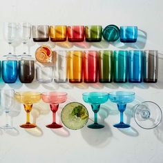 there are many different colored glasses on the table