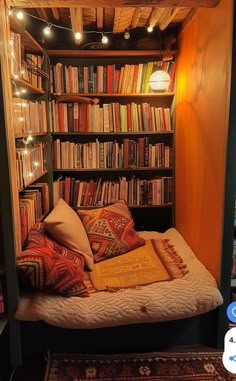 a bed with lots of books on it in front of a book shelf filled with books