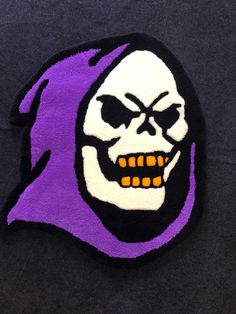 a purple and black patch with a skull on it's face in the shape of a head