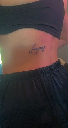 a woman with a tattoo on her stomach that says, lovingly in cursive writing