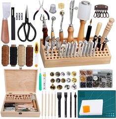 an assortment of tools are displayed in a wooden box with scissors, thread, and other crafting supplies