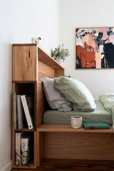 a bed that has some pillows on top of it in a room with white walls