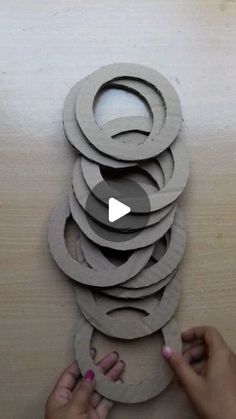 someone is making a sculpture out of cardboard and some paper circles on top of each other