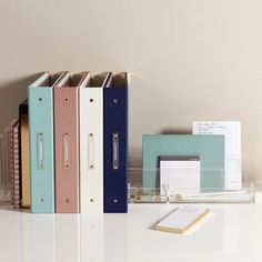 three binders and two books on a desk