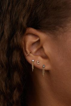 a close up of a woman's ear with two earrings on top of it