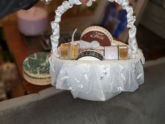 a white basket filled with lots of different types of items on top of a table