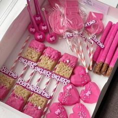 pink and white heart shaped cookies in a box with straws on the table next to them