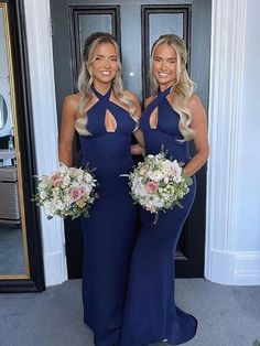 two beautiful women standing next to each other holding bouquets and smiling at the camera