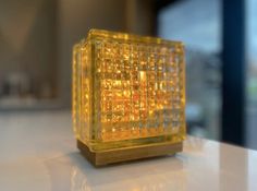 a yellow glass block sitting on top of a table