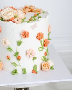 a white cake with orange and pink flowers on it