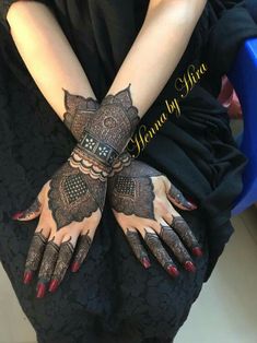 a woman's hands with henna tattoos on them