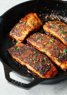 some meat is cooking in a pan on the stove with parsley and seasoning