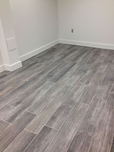 an empty room with wood flooring and white walls