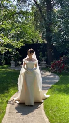 a woman in a wedding dress is walking down the sidewalk